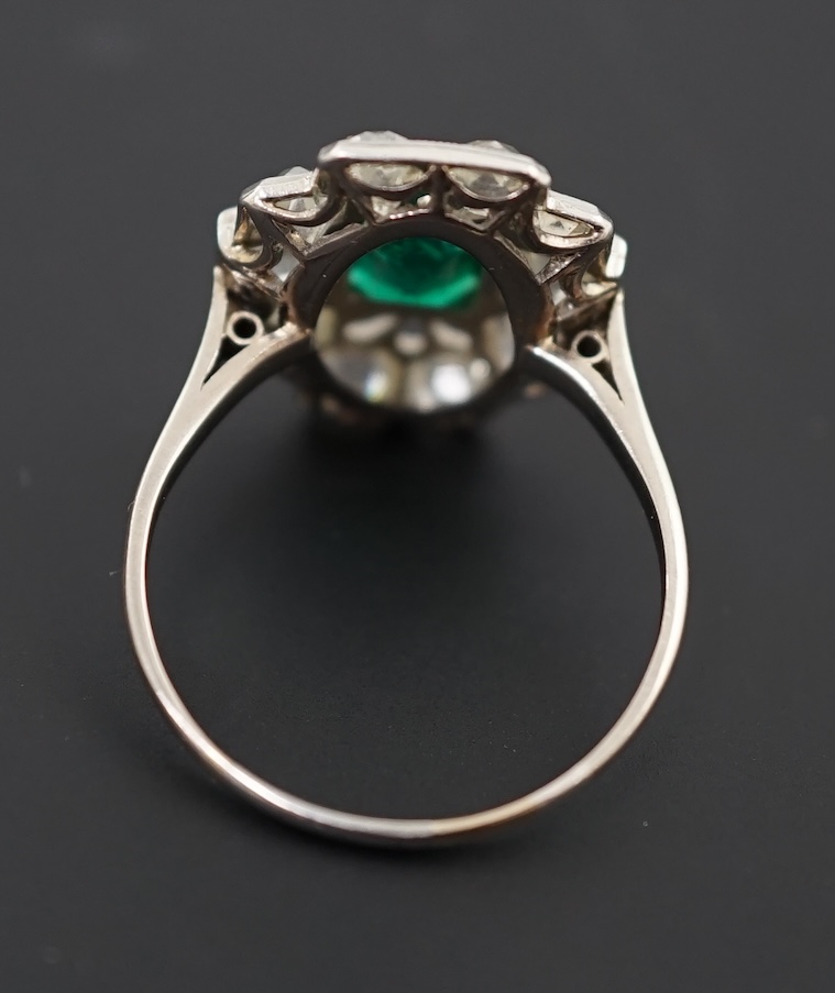 An early to mid 20th century white gold?, emerald and diamond cluster set stepped oval dress ring